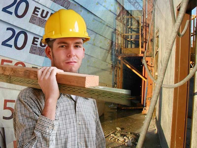 un ouvrier du bâtiment sur le chantier mesure la longueur de l