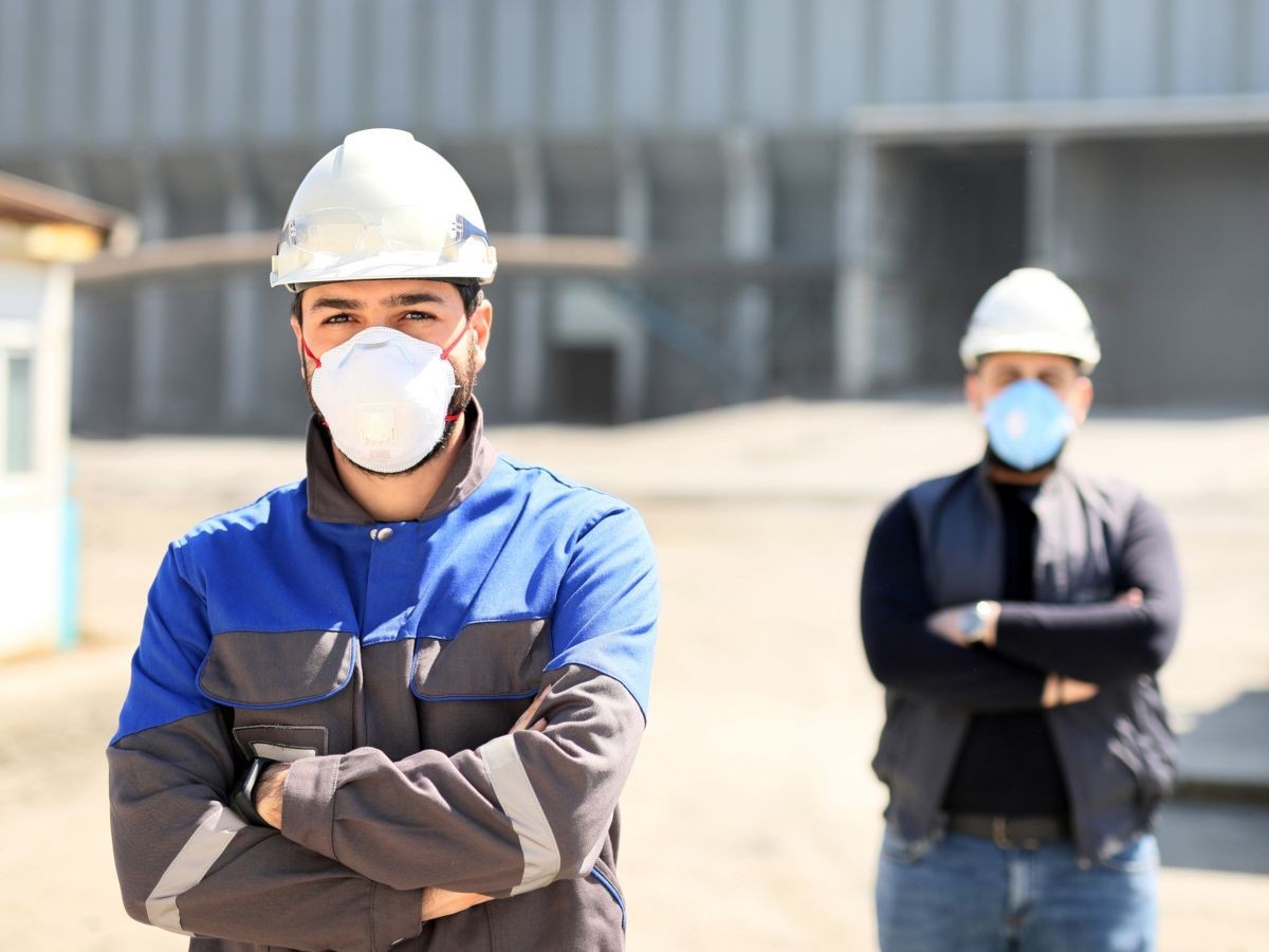 Travailleurs De La Construction Avec Casque Et Port D'un Masque Sur Le  Chantier De Construction Avec Espace De Copie